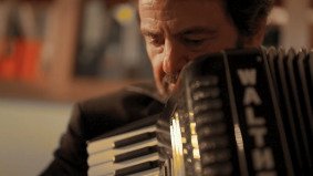 Close-up of an artist playing accordion, captured during a behind-the-scenes moment on a documentary-style video production in China.