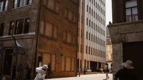 A woman walking on the Bund with Shanghai’s skyline and colonial buildings in the background.
