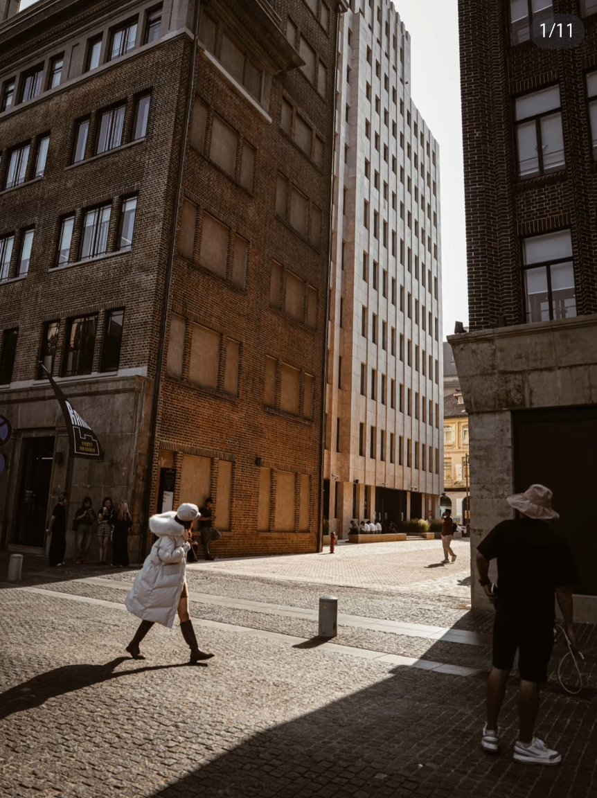 A woman walking on the Bund with Shanghai’s skyline and colonial buildings in the background.