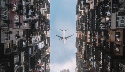Courtyard of Monster Building with airplane overhead – cinematic Hong Kong video shoot location