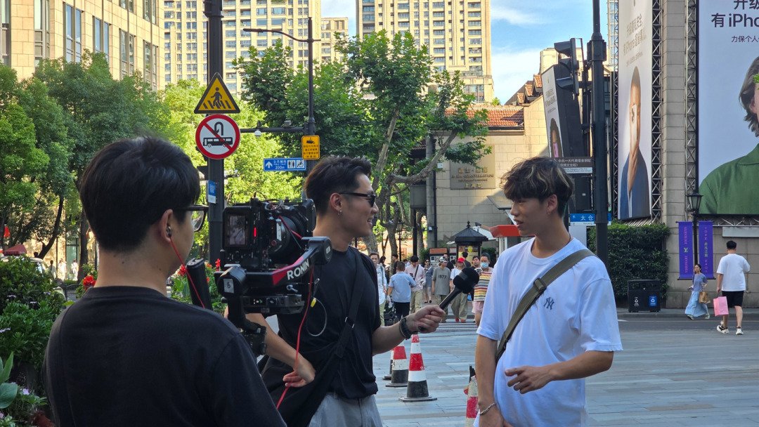Cameraman using FX3 filming host interviewing man on Shanghai’s Huaihai Road with full location permits