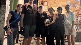 Fixer from Alchemist Films posing with TV video crew in front of a shop under Hong Kong’s Monster Building after a successful shoot — expert China fixer video production support