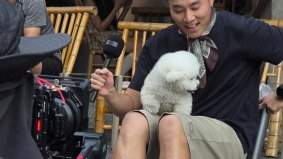Handsome man being interviewed on the street in China with a white dog, filmed for TikTok by Alchemist Films, a China fixer video production company