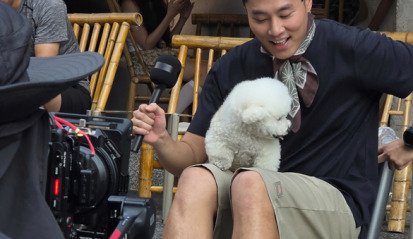 Handsome man being interviewed on the street in China with a white dog, filmed for TikTok by Alchemist Films, a China fixer video production company