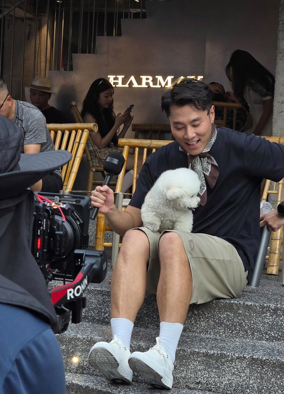 Handsome man being interviewed on the street in China with a white dog, filmed for TikTok by Alchemist Films, a China fixer video production company