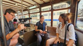 German cameraman and producer filming with German TV host on a tourist double-decker bus in Hong Kong — supported by Alchemist Films, expert China fixer and video production partner