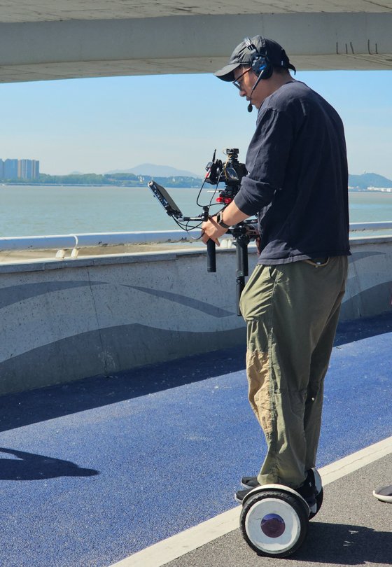 Director of Photography filming with Sony FX3 and stabilizer on a two-wheel vehicle in Hangzhou — supported by Alchemist Films, a China fixer video production company