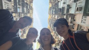 Local fixer Jade standing with German TV crew under the iconic Monster Building in Hong Kong — coordinated by Alchemist Films, a China fixer video production company