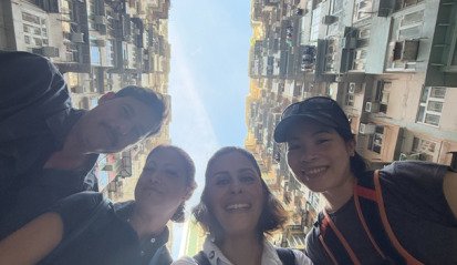 Local fixer Jade standing with German TV crew under the iconic Monster Building in Hong Kong — coordinated by Alchemist Films, a China fixer video production company