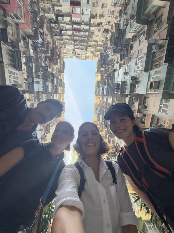 Local fixer Jade standing with German TV crew under the iconic Monster Building in Hong Kong — coordinated by Alchemist Films, a China fixer video production company
