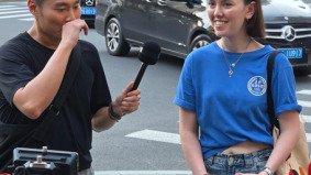 Host interviewing foreign girl on Shanghai street with rolling stabilizer camera operated by Alchemist Films crew