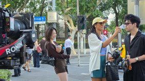 Couple being interviewed on a Shanghai street by a beautiful TikTok host, with the woman smiling brightly — filmed by Alchemist Films, a China fixer video production company