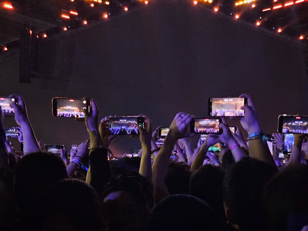 Group of fans holding phones to capture the giant LED screen during VAC Festival in Hefei, live event covered by Alchemist Films video production fixer team in China